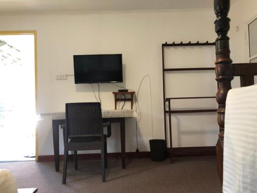 a room with a desk with a television and a chair at No.53 in Katunayake