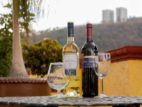 una botella de vino y dos copas de vino en una mesa en Hotel Las Américas en Morelia