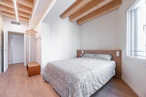a bedroom with a bed and a large window at Palazzo '900 Design Flats - Il Poeta in Padova