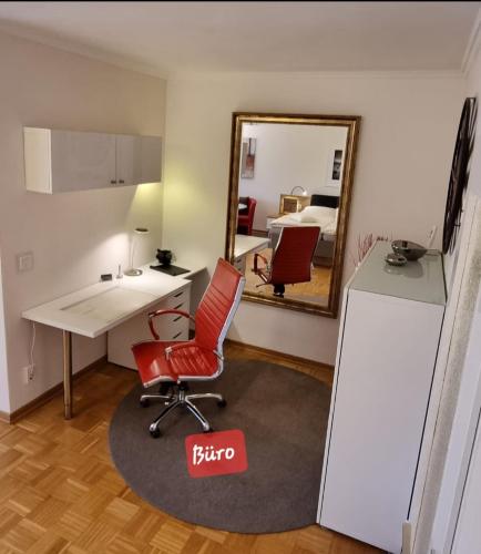 a room with a desk and a red chair and a mirror at Haus - Bonsai Bonsai Apartments I in Bad Pyrmont