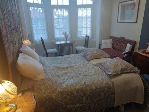 - une chambre avec un lit, un canapé et des fenêtres dans l'établissement Villa des Chats, à Calais