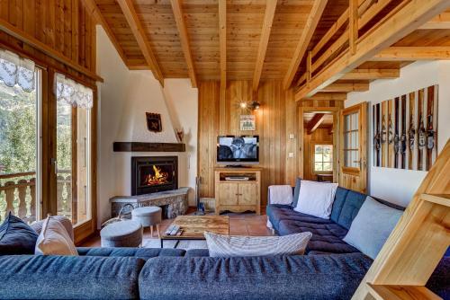 un salon avec un canapé bleu et une cheminée dans l'établissement Chalet Bellevue, à La Tzoumaz