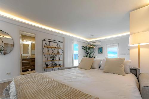sypialnia z dużym białym łóżkiem i łazienką w obiekcie Pámpano Ocean View w Puerto de la Cruz