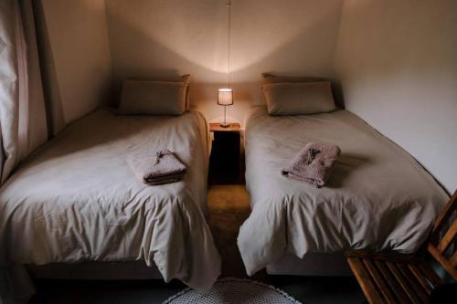 two beds sitting next to each other in a room at Delightful farmhouse with hottub in Goedgemond