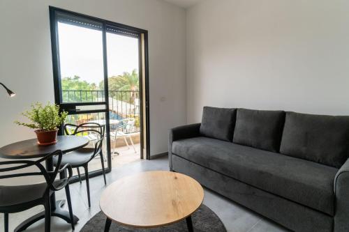ein Wohnzimmer mit einem Sofa und einem Tisch in der Unterkunft Nahal Oz 33 in Tel Aviv