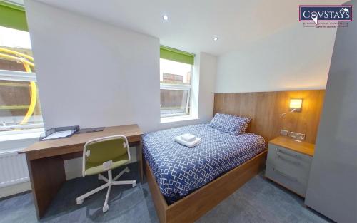 a bedroom with a bed and a desk and a chair at Victoria House - Deluxe Studios in Coventry City Centre, free parking, by COVSTAYS in Coventry