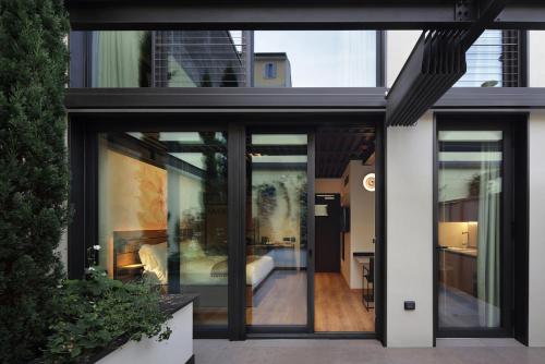 a house with large glass doors and a bedroom at VERSOVERDE HOTEL Alzaia Naviglio Grande in Milan