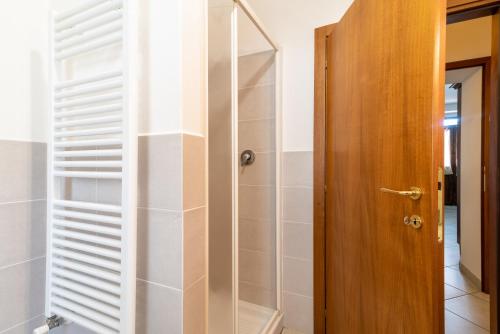 een badkamer met een douche en een houten deur bij Papà Giuseppe La Stalla in Cortona