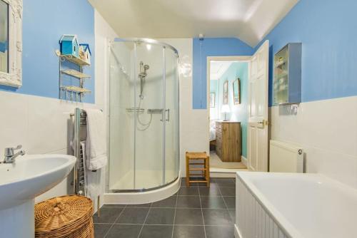uma casa de banho com um chuveiro, um lavatório e uma banheira em Honeysuckle Cottage em Whitstable