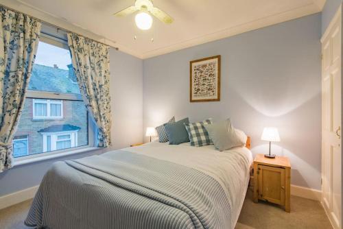 um quarto com uma cama grande e uma janela em Honeysuckle Cottage em Whitstable