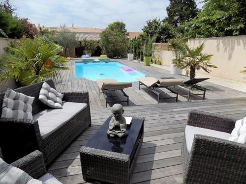 une cour avec une piscine et des meubles en osier dans l'établissement Appartement 45m2 à Bordeaux avec accès piscine, à Bordeaux