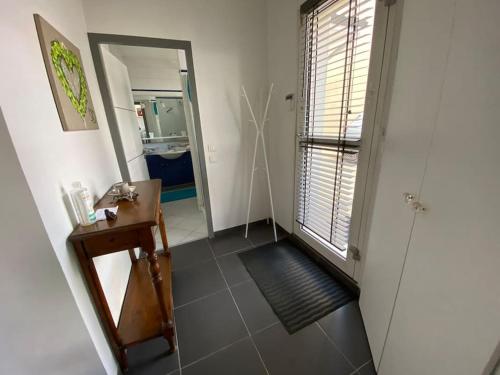 - un couloir avec une salle de bains pourvue d'une table et d'un miroir dans l'établissement Appartement 45m2 à Bordeaux avec accès piscine, à Bordeaux