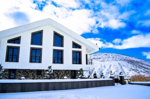 una casa blanca frente a una montaña cubierta de nieve en Ultra Luxury Chalet near Cappadocia - up to 9 people, en Kayseri