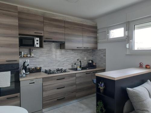 a kitchen with wooden cabinets and a stove top oven at Apartman Ines in Velika Gorica