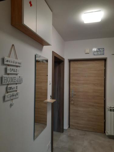 a hallway with two wooden doors and a sign on the wall at Apartman Ines in Velika Gorica