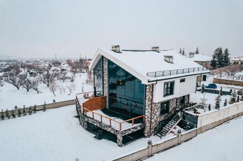 een huis in de sneeuw met een sneeuwbedekte tuin bij Ultra Luxury Chalet near Cappadocia - up to 9 people in Kayseri