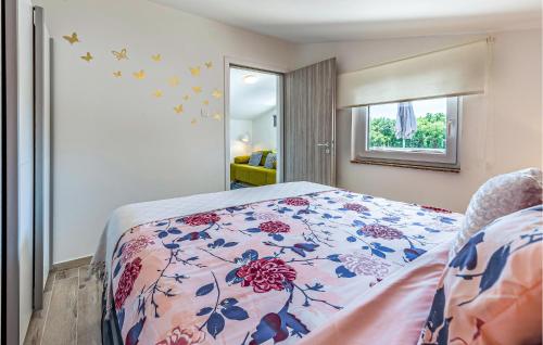 1 dormitorio con 1 cama con colcha de flores en Beautiful Home In Kavran With Kitchen, en Kavran