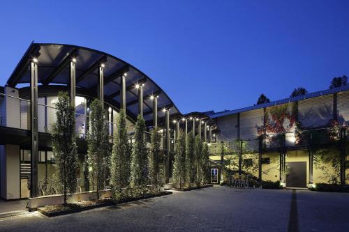 Un bâtiment avec quelques arbres devant lui dans l'établissement VERSOVERDE HOTEL Alzaia Naviglio Grande, à Milan