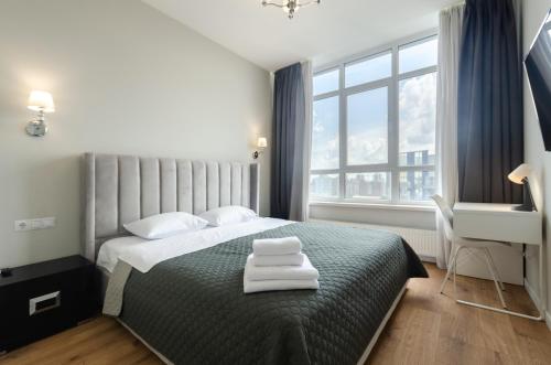 ein Schlafzimmer mit einem Bett mit zwei Handtüchern darauf in der Unterkunft 28485 Central park apartments in Kiew