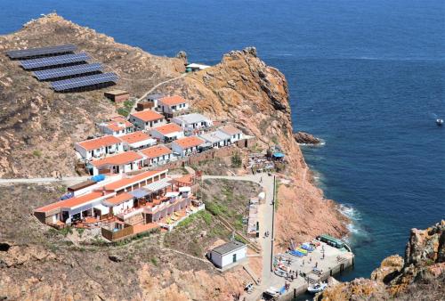 a house on a cliff next to the ocean at BerlengaBed&Breakfast in Peniche