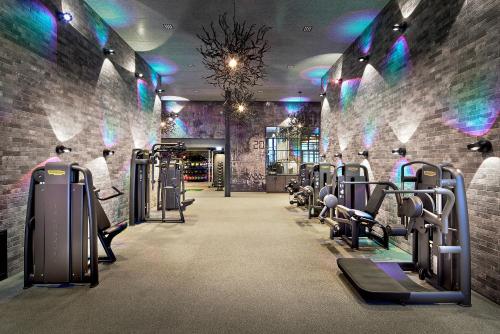 a gym with rows of cardio equipment in a brick wall at Wellness- & Sporthotel Jagdhof in Röhrnbach