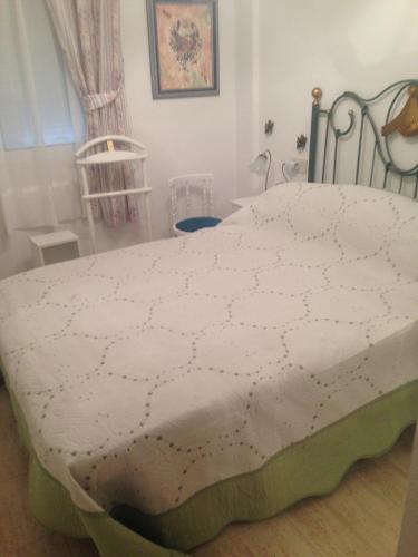 a bedroom with a bed with a white comforter at EXCEPTIONNEL APPARTEMENT EN ESPAGNE in Torrevieja