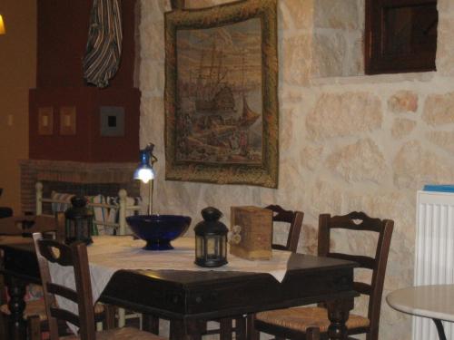 a dining room table with chairs and a painting on the wall at Alegria Villas Complex in Vasilikos