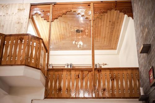 una escalera de madera ornamentada en una casa en Tales N Trails, en Bashist