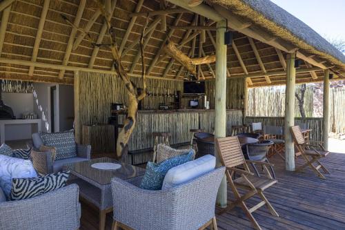 a pavilion with chairs and tables on a deck at TimBila Camp Namibia in Omaruru