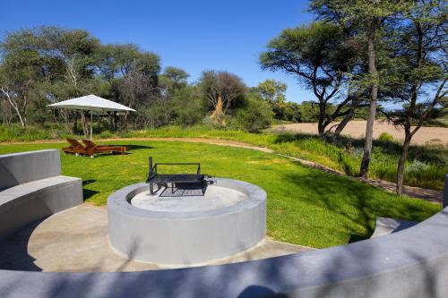 TimBila Camp Namibia في أومارورو: حديقة مع مقعد وطاولة نزهة