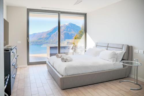 1 dormitorio con cama y ventana grande en THE VIEW!!! by Design Studio, en Perledo