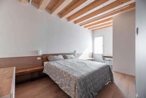 1 dormitorio con cama y mesa de madera en Palazzo '900 Design Flats - Il Pittore, en Padua