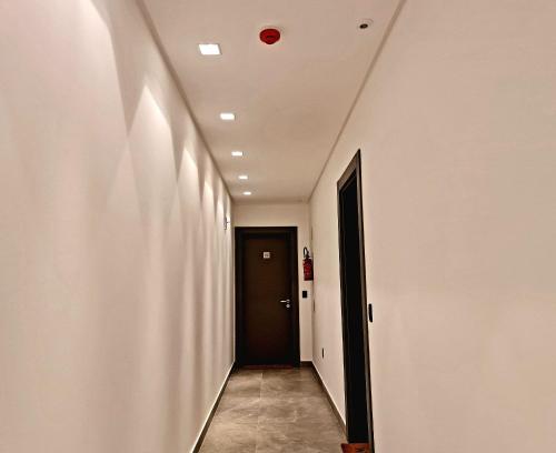 a hallway with a black door and a ceiling at Seasons BC in Cabeçudas