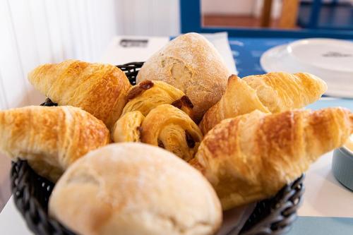een mand met croissants en brood op een tafel bij BerlengaBed&Breakfast in Peniche