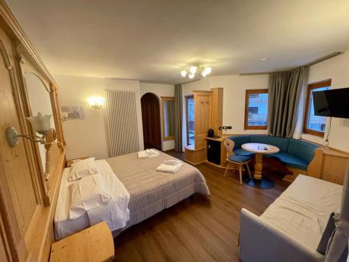 サン・マルティーノ・ディ・カストロッツァにあるHotel Villa Auroraのベッドとデスクが備わるホテルルームです。