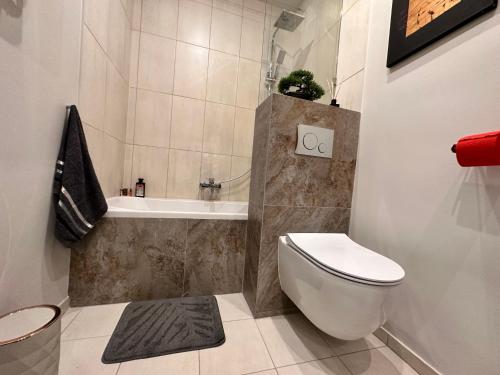 a small bathroom with a toilet and a bath tub at Be Inn - Luxury Apartment Gliwice in Gliwice