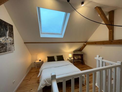 um quarto com uma cama e uma clarabóia em Le passage des cinq - 5 min du tram 15 min Strasbourg centre em Eckbolsheim