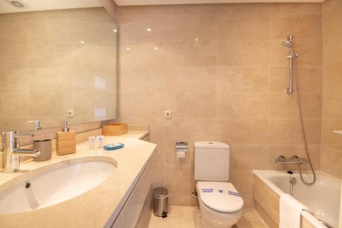 e bagno con vasca, servizi igienici e lavandino. di 2237-Modern apt with private beach a Estepona