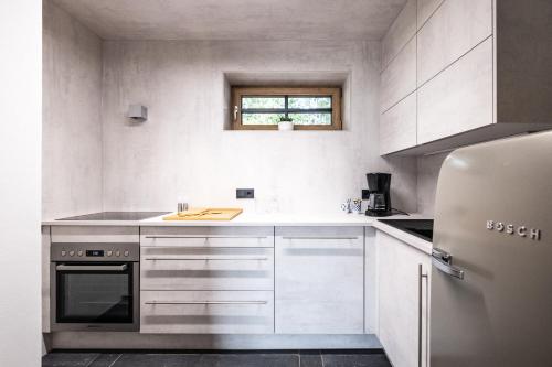 a kitchen with white cabinets and a refrigerator at Ein JUWEL "zum-Auerhahn" in Modriach