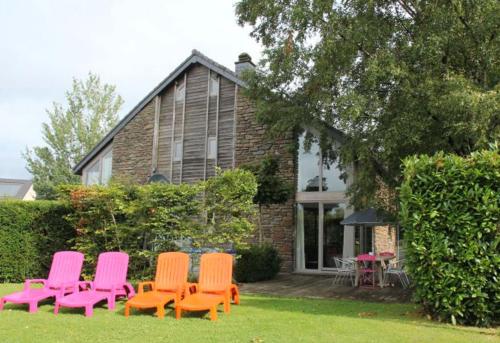 un groupe de chaises roses et oranges devant une maison dans l'établissement Gite-ardennes & wellness - Ovifat - Orchidées 8 pers & Coquelicots 7 pers, à Ovifat