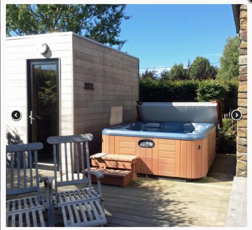 a outdoor kitchen with a stove and two chairs at Gite-ardennes & wellness - Ovifat - Coquelicots 7 pers in Ovifat