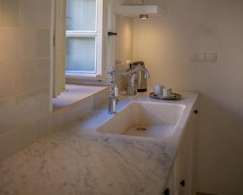 a bathroom with a marble sink and a window at Revelin Hvar in Stari Grad