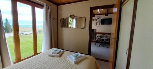 um quarto com uma cama com duas toalhas em Cabañas Oyikil em El Calafate