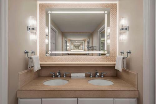 a bathroom with two sinks and a large mirror at Rancho Bernardo Inn in Rancho Bernardo