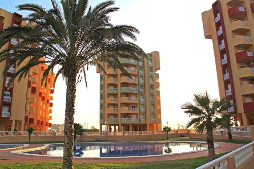 un par de palmeras delante de algunos edificios en Los Miradores, La Manga del Mar Menor, en Murcia