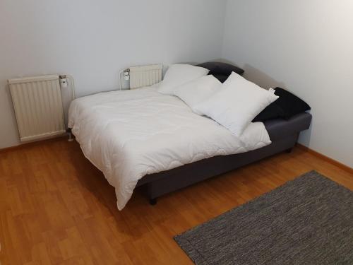 a bed with white sheets and pillows in a room at Edullinen majoitus Ähtärissä! in Ähtäri
