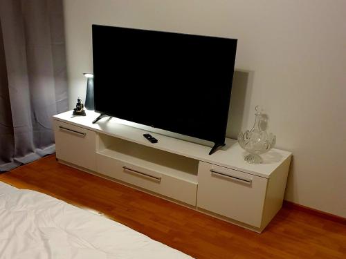 a flat screen tv sitting on a white dresser at Edullinen majoitus Ähtärissä! in Ähtäri