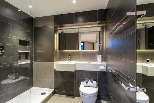 y baño con aseo, lavabo y espejo. en Studio come 1 Bed flat in Vauxhall next to Battersea, en Londres