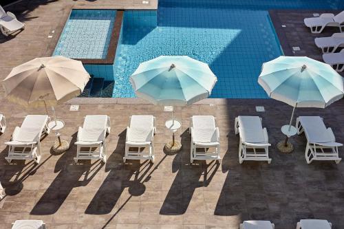 an overhead view of chairs and umbrellas next to a swimming pool at Golden Hotel in Marina di Cecina