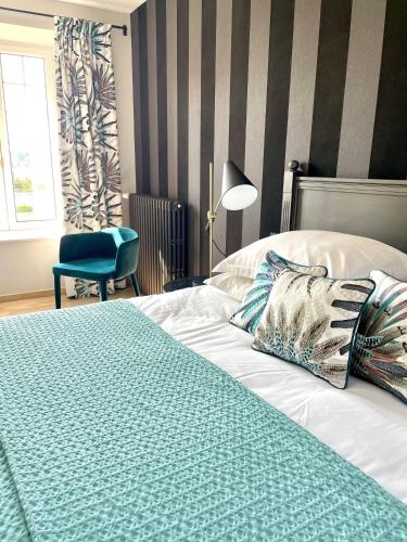a bedroom with a bed and a chair and a window at La Maison Gervaiserie & Spa in Réville
